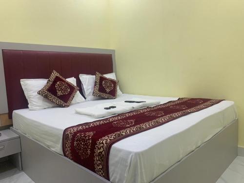 孟买Hotel Sai Plaza, Chembur Mumbai的一间卧室配有一张带红色和白色枕头的大床