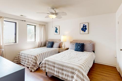 大洋城Tiburon 2C的带2扇窗户的客房内的2张床