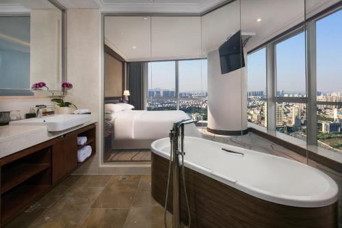 南京南京金丝利喜来登酒店的一间带床、浴缸和水槽的浴室