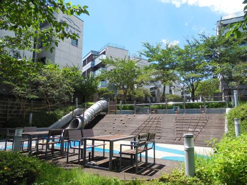 西归浦市汉拿山度假村的一个带桌椅的游泳池以及水滑梯