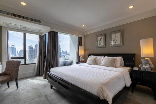 曼谷Cape House Langsuan Hotel的一间卧室设有一张大床和一个大窗户