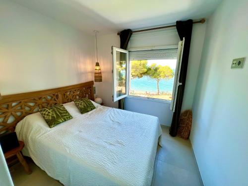 罗萨斯Almadrava Paradise的一间卧室设有一张床和一个大窗户