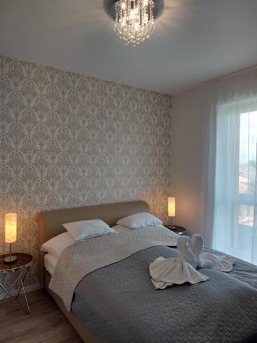 NyergesújfaluPaskom Apartmanház的一间卧室配有一张带天鹅的床
