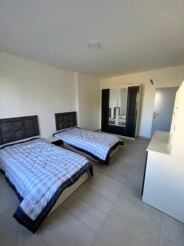 Al KhalīlGerman-Palestinian Appartement的一间卧室配有两张床和镜子
