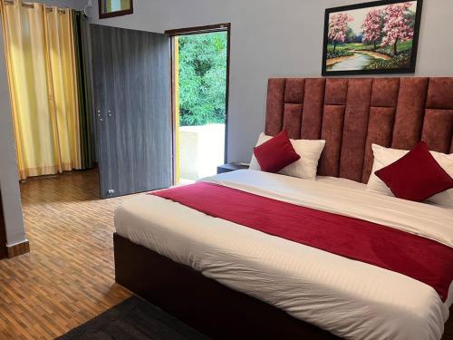 兰纳加The HeartWood Farms Inn的一间卧室配有一张带红色枕头的大床