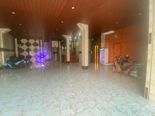 Hoi NghiaKhách Sạn Hội Nghĩa Bình Dương的大厅,有两辆摩托车停在大楼里
