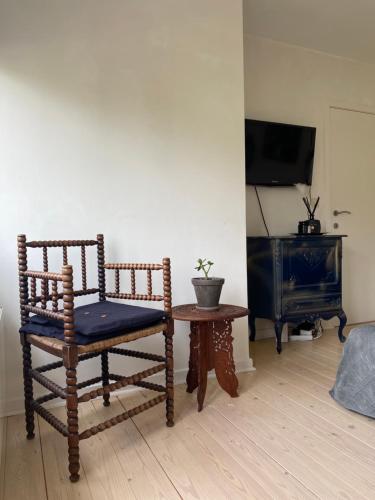 圣马尔滕斯·拉特姆Charming rooms in green area的一间带椅子和桌子的房间以及一台电视