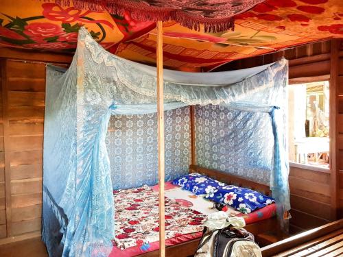 邦隆Farmer home stay & trekking的卧室配有一张位于房子内的天蓬床