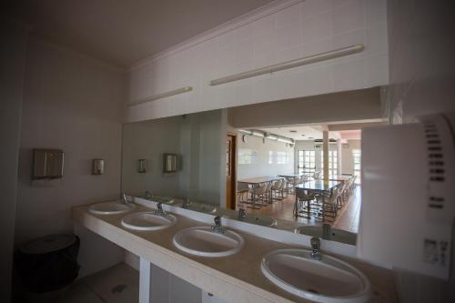 波尔蒂芒HI Portimão - Pousada de Juventude的一间带三个水槽和大镜子的浴室
