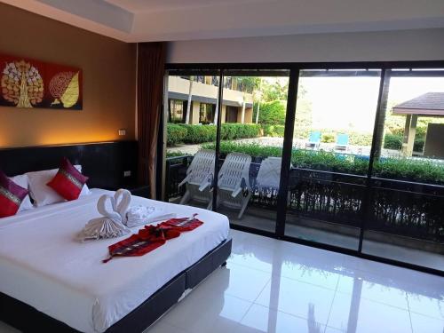 奈扬海滩Naiyang Beach Hotel SHA Plus的一间卧室设有一张床,阳台设有游泳池