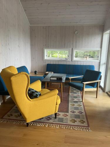 Nord TorpaSykkelhytte ved Slåtten i Synnfjellet的客厅配有黄色椅子和桌子
