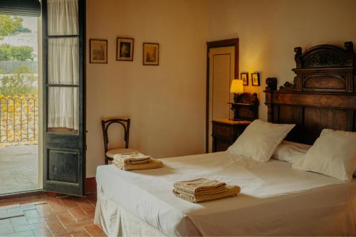 Vilobi Del PenedesCasa Rural Cal Gotlla的一间卧室配有一张床,上面有两条毛巾