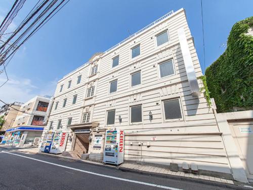 东京HOTEL LiVEMAX BUDGET Nippori的街道边的白色建筑