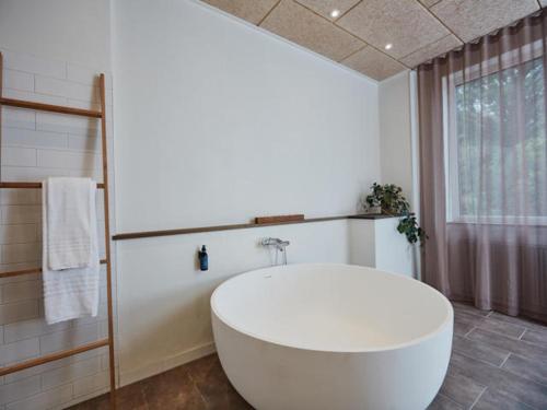 格罗斯滕本尼克卡尔德酒店的一间带大型白色浴缸和窗户的浴室