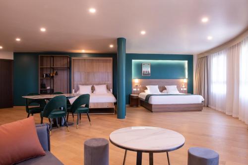 锡河边的圣奥班Golden Tulip Dieppe Hôtel & Spa的酒店客房带两张床和一张桌子以及椅子。