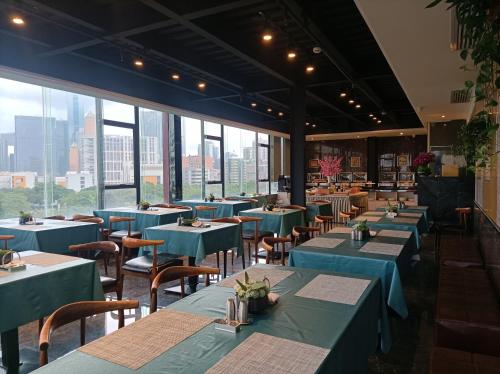 广州Paco Hotel Shuiyin Road Guangzhou-Canton Fair free shuttle bus的餐厅设有蓝色的桌椅和窗户。