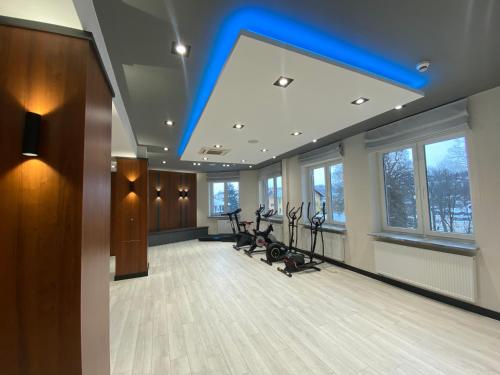 伊沃尼奇-兹德鲁伊Amelia Zdroj Medical & Spa的一间拥有蓝色天花板的健身房,里面配有健身自行车