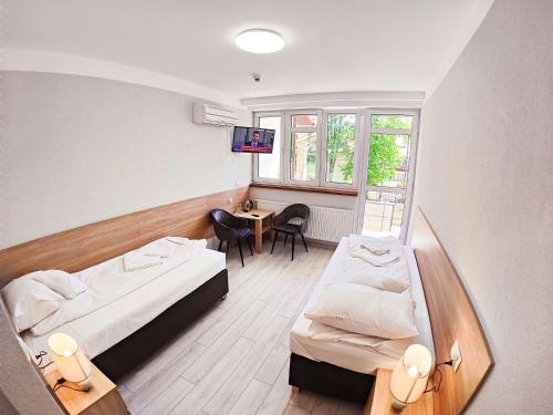 伊沃尼奇-兹德鲁伊Amelia Zdroj Medical & Spa的客房设有两张床和一张带电视的桌子。