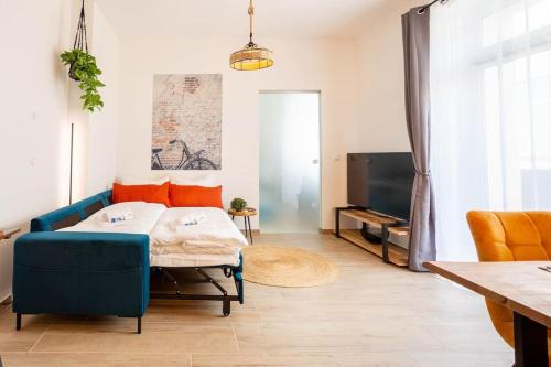 茨维考FeelgooD Apartments DELUXE Zwickau CityCenter mit TG-Stellplatz, Netflix und Waipu-TV的客厅配有蓝色的沙发和电视