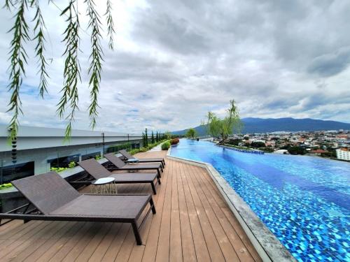 清迈Astra Sky River Chiang Mai的一座带躺椅的游泳池位于一座建筑的顶部