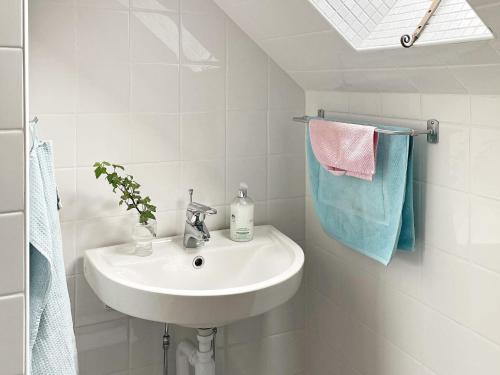 龙讷比Holiday home RONNEBY X的白色的浴室设有水槽和毛巾。