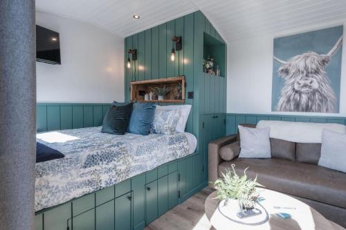 桑德斯富特Willows Rest - 1 Bed Shepherds Hut - Pentlepoir的一间卧室配有一张床和一张沙发