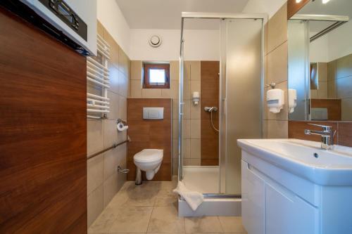 米兹多洛杰Apartamenty Gromada Międzyzdroje的浴室配有卫生间、盥洗盆和淋浴。
