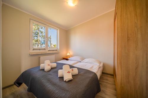 米兹多洛杰Apartamenty Gromada Międzyzdroje的一间卧室配有两张床和白色毛巾。