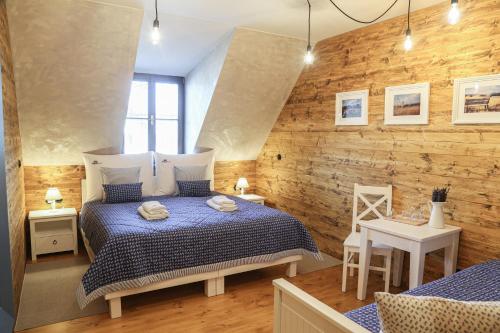 Soběsuky昂格斯法姆旅馆的一间卧室设有一张床和木墙