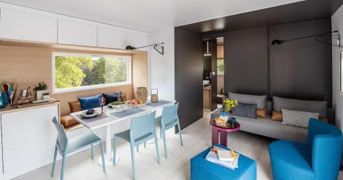 Saint-Crépin-et-CarlucetCamping LE PIGEONNIER的厨房以及带桌子和蓝色椅子的客厅。