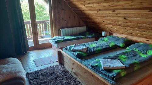 Lom nad RimavicouKoliba Drabsko的木窗间内的两张单人床
