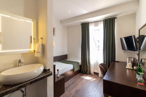 杜塞尔多夫Jupa's Hotel的一间带水槽的浴室和一张位于客房内的床