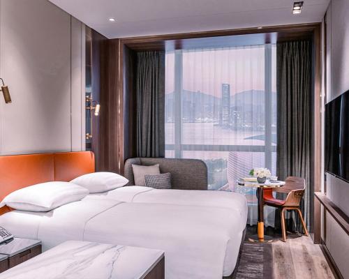 香港Dorsett Kai Tak的酒店客房设有两张床和窗户。