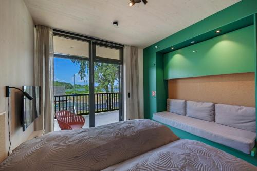 霍尔滕RS Noatun的一间卧室配有一张床和一张沙发,并设有一个阳台