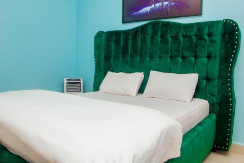 坎帕拉Rare APT for solo and couple Travellers的一间卧室配有一张大床和绿色床头板