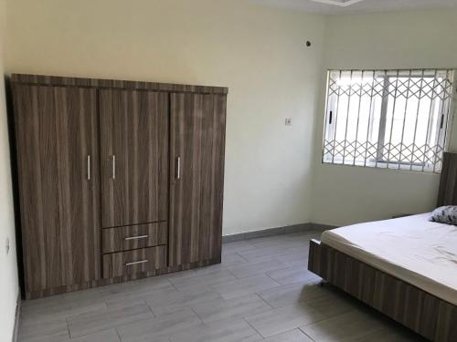 塔马拉Buzu Apartments的一间卧室配有一张位于床边的大型木制橱柜
