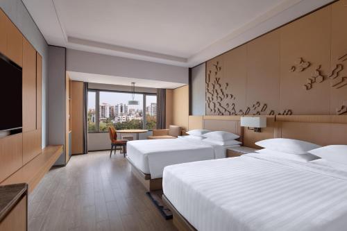 苏拉特Surat Marriott Hotel的酒店客房设有两张床和电视。