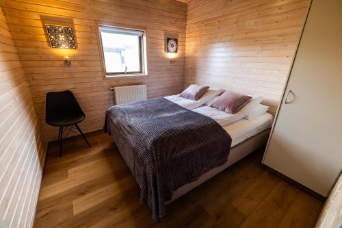 ÚthlidEfsti-Dalur Cottages的一间小卧室,配有一张木墙床