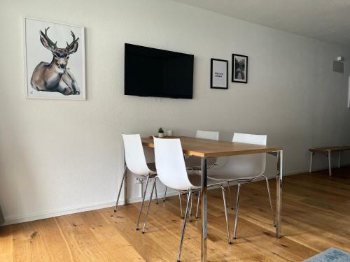 伦策海德Ferienwohnung 405 Haus Allod的一间设有桌子和墙上鹿的用餐室