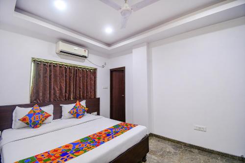 加尔各答FabHotel Rani Tower的一间卧室配有一张带色彩缤纷枕头的大床