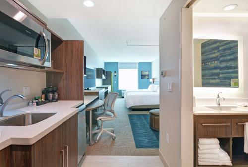 贝滕多夫Home2 Suites By Hilton Bettendorf Quad Cities的酒店客房设有厨房和卧室