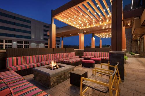 麦迪逊Home2 Suites By Hilton Madison Central Alliant Energy Center的屋顶庭院设有红色的沙发和火坑