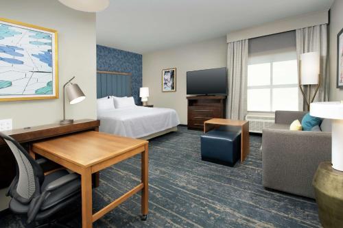丹佛Homewood Suites By Hilton Denver Airport Tower Road的配有一张床和一张书桌的酒店客房