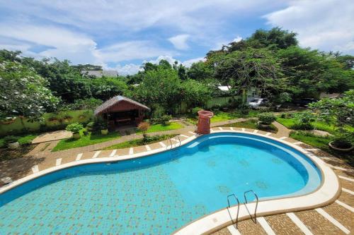 公主港Hanbee's Resort的一座大游泳池,位于一个树木繁茂的庭院内