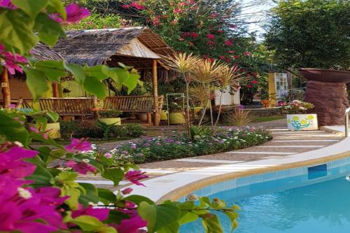 公主港Hanbee's Resort的一个带游泳池和鲜花的花园