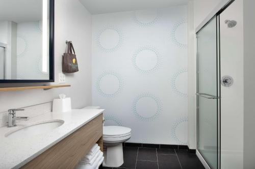 拉皮德城Tru By Hilton Rapid City Rushmore, Sd的一间带卫生间和玻璃淋浴间的浴室