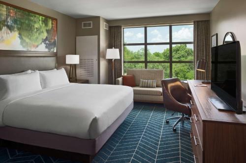 伯尼The Bevy Hotel Boerne, A Doubletree By Hilton的酒店客房配有一张床、一张书桌和一台电视。