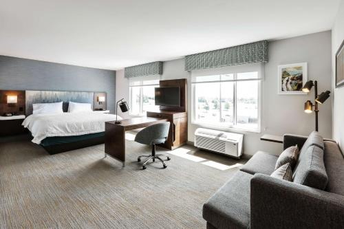 魁北克市Hampton Inn & Suites by Hilton Québec - Beauport的配有一张床和一张书桌的酒店客房