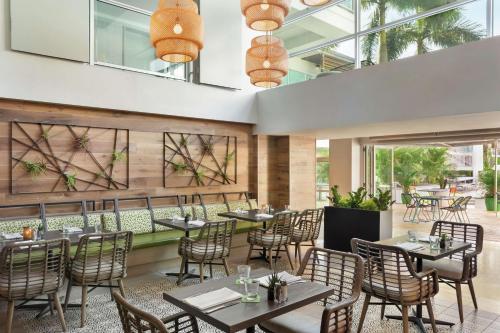 坦帕坦帕西岸皇冠假日酒店的餐厅设有桌椅和窗户。