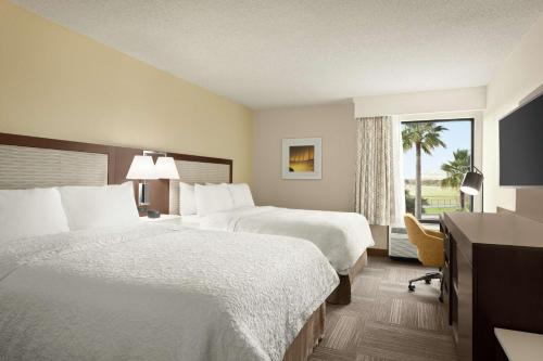 休斯顿休斯敦霍比机场希尔顿恒庭酒店的酒店客房设有两张床和窗户。